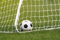 Football Ball in a Goal. Soccer Ball Lying in Grass. Football Equipment Royalty Free Stock Photo