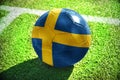 Football ball with the national flag of sweden lies on the green field Royalty Free Stock Photo