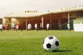 Football ball in the stadium. Soccer background. Classic soccer ball lying in the grass. Players kicking game at the soccer pitch Royalty Free Stock Photo