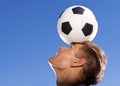 Football, bounce and head with man, sports and training with competition and exercise. Person, blue sky and player with