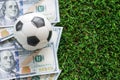 Football Business Concept : A fooball on dollar bills and green