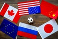 Football championat. American, Canadian, European, Japanese, China, Russian flags and football ball on dark wooden