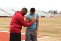 Football coach coaching an athlete