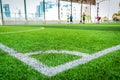 Corner white line on green artifact grass of soccer indoor pitch Royalty Free Stock Photo