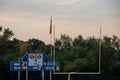 Football end zone with goal posts, Amercian flag and score board during evening sunset Royalty Free Stock Photo