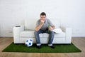 Football fan watching tv match on sofa with grass pitch carpet i Royalty Free Stock Photo