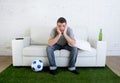 Football fan watching tv match on sofa with grass pitch carpet i Royalty Free Stock Photo