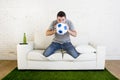 Football fan watching tv match on sofa with grass pitch carpet i Royalty Free Stock Photo