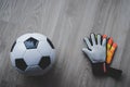 Football Goalkeeper gloves and soccer ball top view on wooden backgorund with copy space Royalty Free Stock Photo