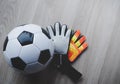 Football Goalkeeper gloves with soccer ball top view on wooden background copy space Royalty Free Stock Photo