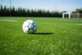 a football on a green field with white boundary markings