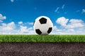 Football on green grass with soil on blue sky Royalty Free Stock Photo