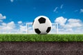 Football on green grass with soil on blue sky Royalty Free Stock Photo