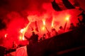 Football hooligans with mask holding torches in fire