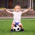 Football lesson in kindergarten preschool outdoors: little blonde goalkeeper protecting soccer goalposts with arms wide open Royalty Free Stock Photo