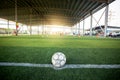 Football at penalty spot on green artificial turf with blurry soccer team training, blurry kid soccer player jogging between Royalty Free Stock Photo