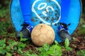 A soiled football placed under the boots of a player