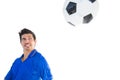 Football player in blue jumping to ball Royalty Free Stock Photo