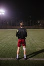 football player doing warm up exercises on the field before the match at night