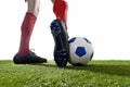 Football player in red socks and black shoes running and dribbling with the ball playing on grass Royalty Free Stock Photo