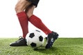 Football player in red socks and black shoes running and dribbling with the ball playing on grass Royalty Free Stock Photo