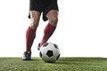 Football player in red socks and black shoes running and dribbling with the ball playing on grass Royalty Free Stock Photo