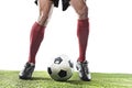 Football player in red socks and black shoes running and dribbling with the ball playing on grass Royalty Free Stock Photo