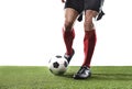 Football player in red socks and black shoes running and dribbling with the ball playing on grass Royalty Free Stock Photo