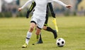 Football Player Running Ball. Soccer Referee with Flag in Hand in the Background