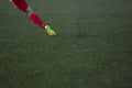 The football player is shooting the football ball on artificial turf field