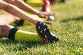 Football Player Stretches Sitting on Grass Pitch. Stretching Session After Workout For Footballers Royalty Free Stock Photo