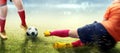 Football player woman in orange jersey sliding tackle the ball from her opponent Royalty Free Stock Photo