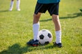 Football players feet close up. Sports training on a grass field background. Boy in a sportswear. Player wearing white football Royalty Free Stock Photo