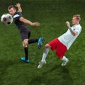 Football players tackling ball over green grass background Royalty Free Stock Photo