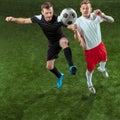 Football players tackling ball over green grass background Royalty Free Stock Photo