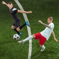 Football players tackling ball over green grass background Royalty Free Stock Photo
