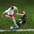 Football players tackling ball over green grass background Royalty Free Stock Photo