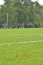 On a football practise and on a green field on a rainy, cold and grey Autumn afternoon with soccer players on a background