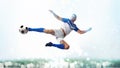 Soccer striker hits the ball with an acrobatic kick in the air on white background Royalty Free Stock Photo