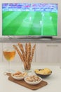 Football snacks and football game on tv on the background Supporting national team concept Football fan food Royalty Free Stock Photo