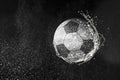 Football, soccer ball flying in water drops and splashes isolated on black background Royalty Free Stock Photo