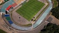 Football stadium in the city park. A green field and stands are visible, painted in different colors. Close-up shot. Aerial Royalty Free Stock Photo