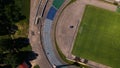 Football stadium in the city park. A green field and stands are visible, painted in different colors. Close-up shot. Aerial Royalty Free Stock Photo