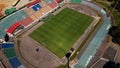 Football stadium in the city park. A green field and stands are visible, painted in different colors. Close-up shot. Aerial Royalty Free Stock Photo