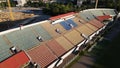 Football stadium in the city park. A green field and stands are visible, painted in different colors. Close-up shot. Aerial Royalty Free Stock Photo