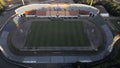 Football stadium in the city park. A green field and stands are visible, painted in different colors. Close-up shot. Aerial Royalty Free Stock Photo