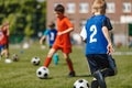 Football Summer Training Camp For School Kids. Soccer Players Running Classic Soccer Ball on Natural Grass Field Royalty Free Stock Photo