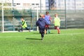 Football team - boys in red and blue, green uniform play soccer on the green field. Team game, training, active lifestyle