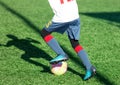 Football teams - boys in red, blue, white sportswear play soccer on the green field. boys dribbling. dribbling skills. Team game,