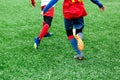 Football teams - boys in red, blue, white uniform play soccer on the green field. boys dribbling. dribbling skills. Royalty Free Stock Photo